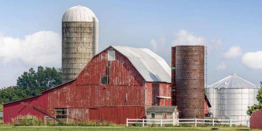 View of a farm featuring a large red barn and silo