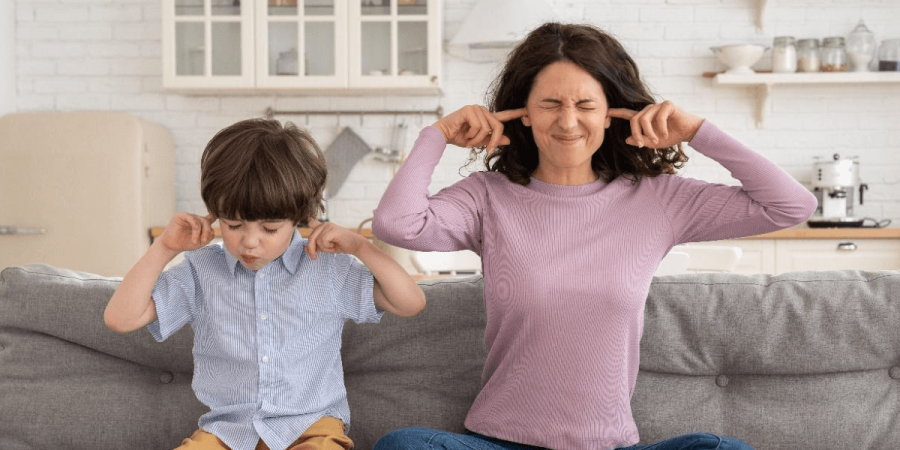 A mother and child blocking their ears from the chirping in the attic.